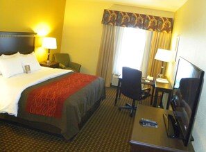 A hotel room with a bed, a desk, a chair, a lamp, and a television. - Comfort Inn & Suites Regional Medical Center (Abilene)