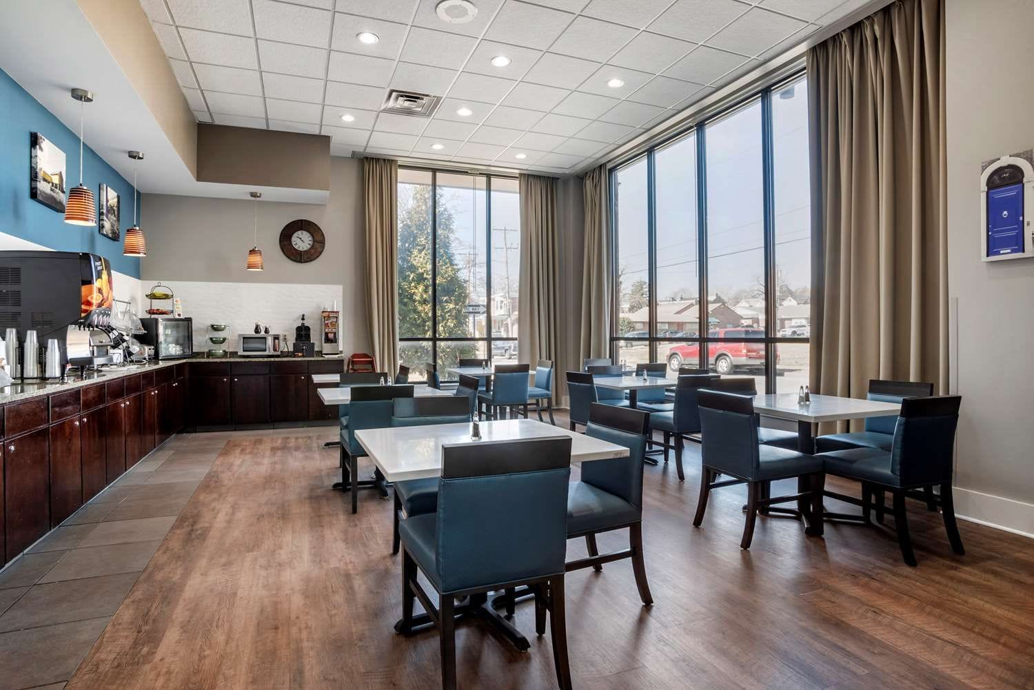 Ein Restaurant mit Barbereich, großen Fenstern und Ausblick nach draußen.