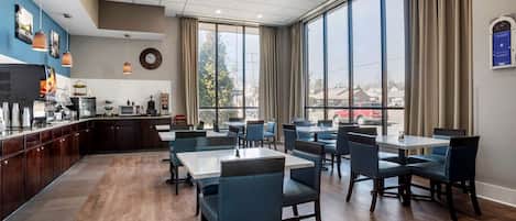 Ein Restaurant mit Barbereich, großen Fenstern und Ausblick nach draußen.