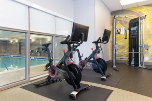 A gym with stationary bikes, a pull-up bar, and a weight machine.
