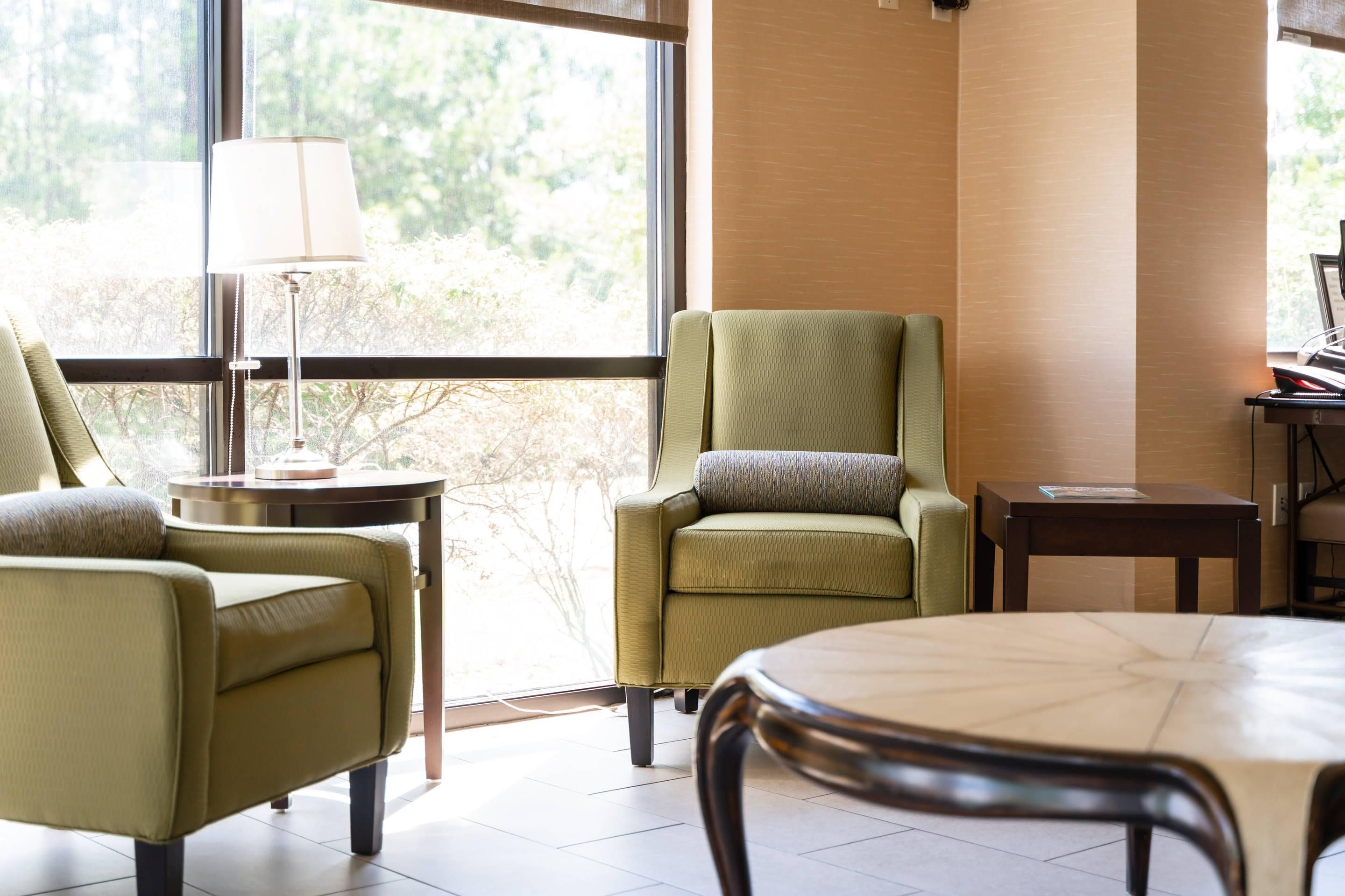 A modern living room with a sofa, armchair, and a round table.