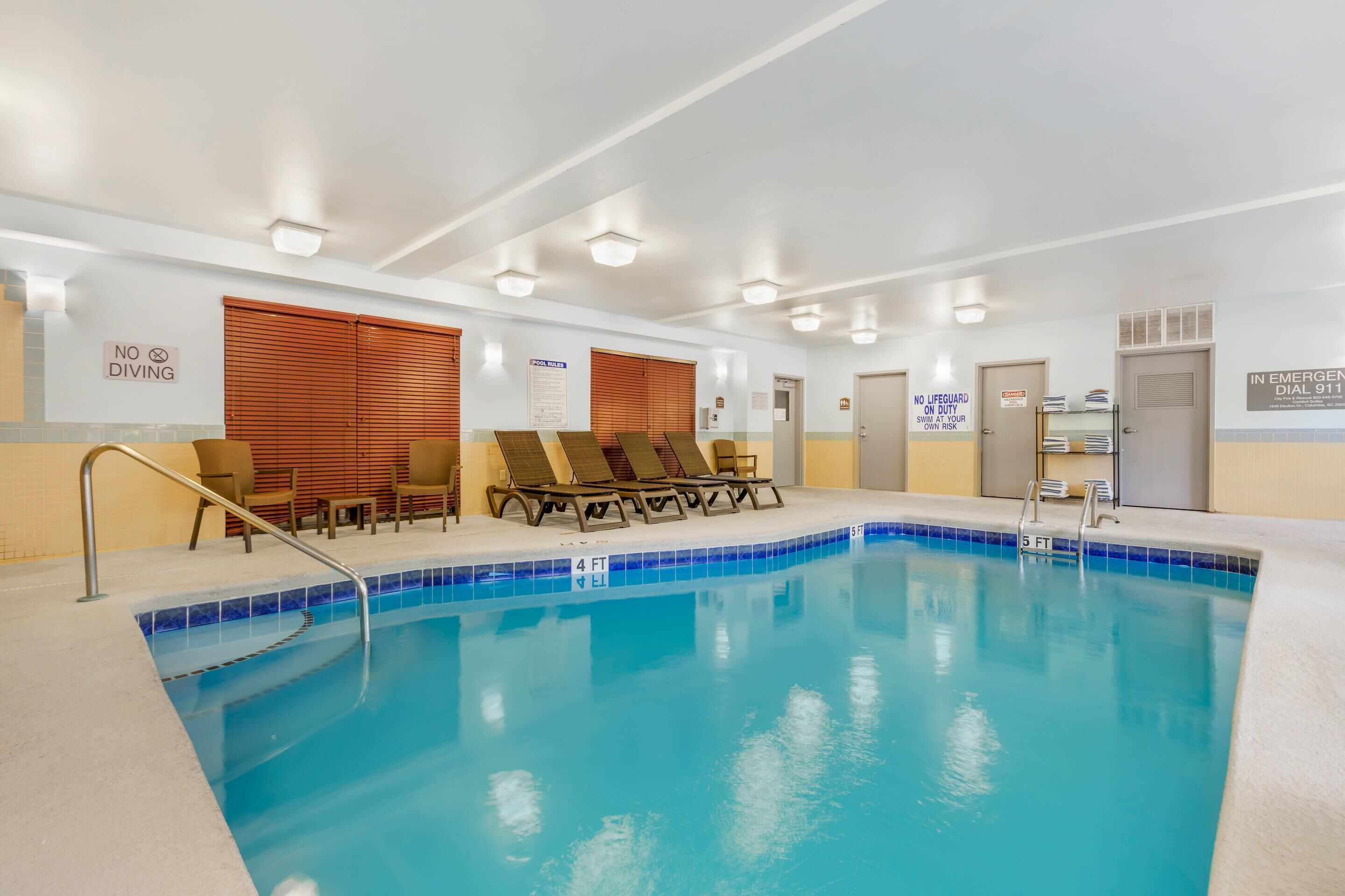 A swimming pool with lounge chairs and a no diving sign.