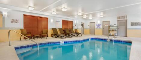 A swimming pool with lounge chairs and a no diving sign.