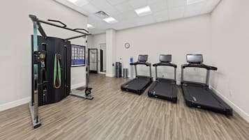 A gym with treadmills, a stationary bike, and a weight machine.
