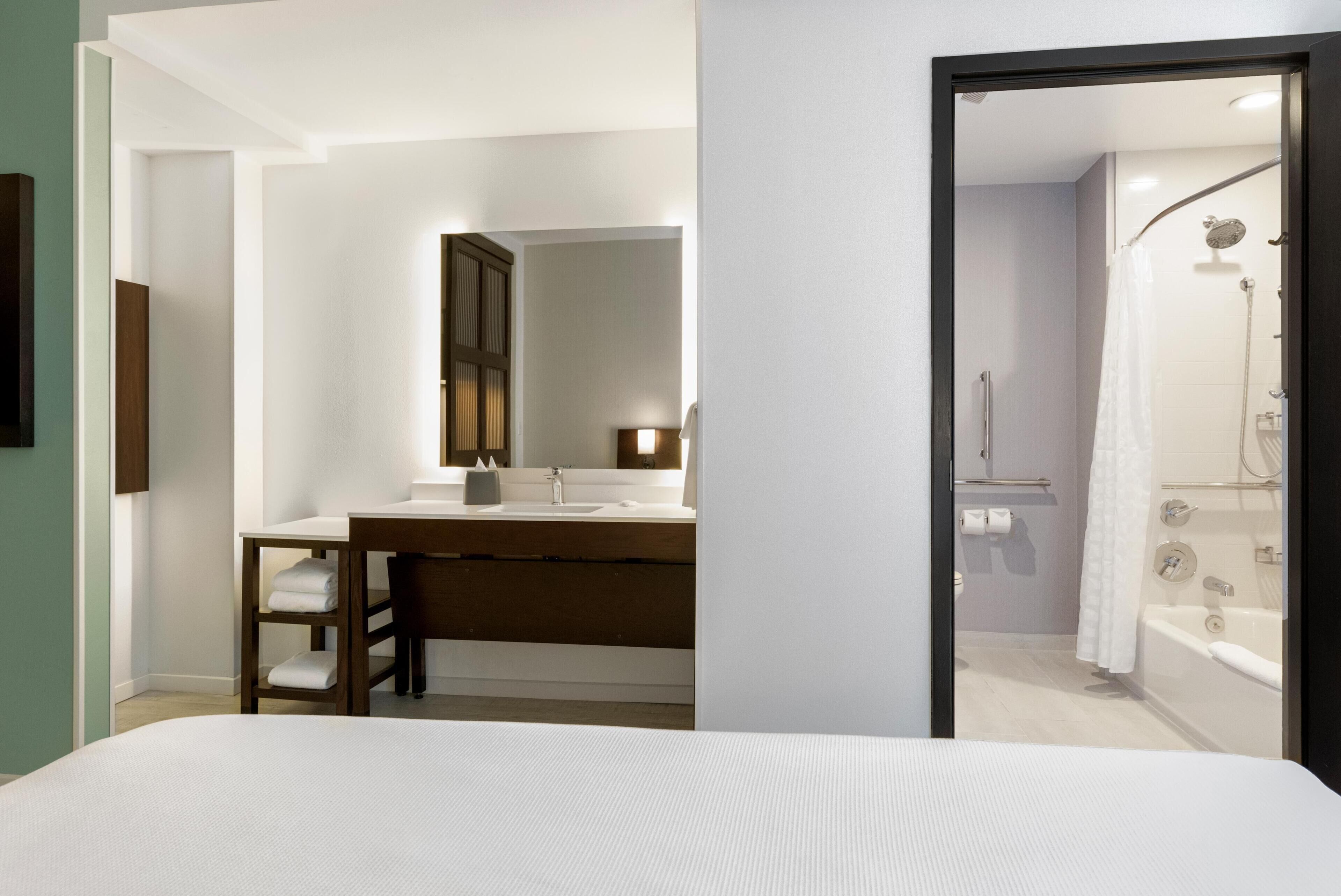A modern bathroom with a shower, a sink, and a mirror.