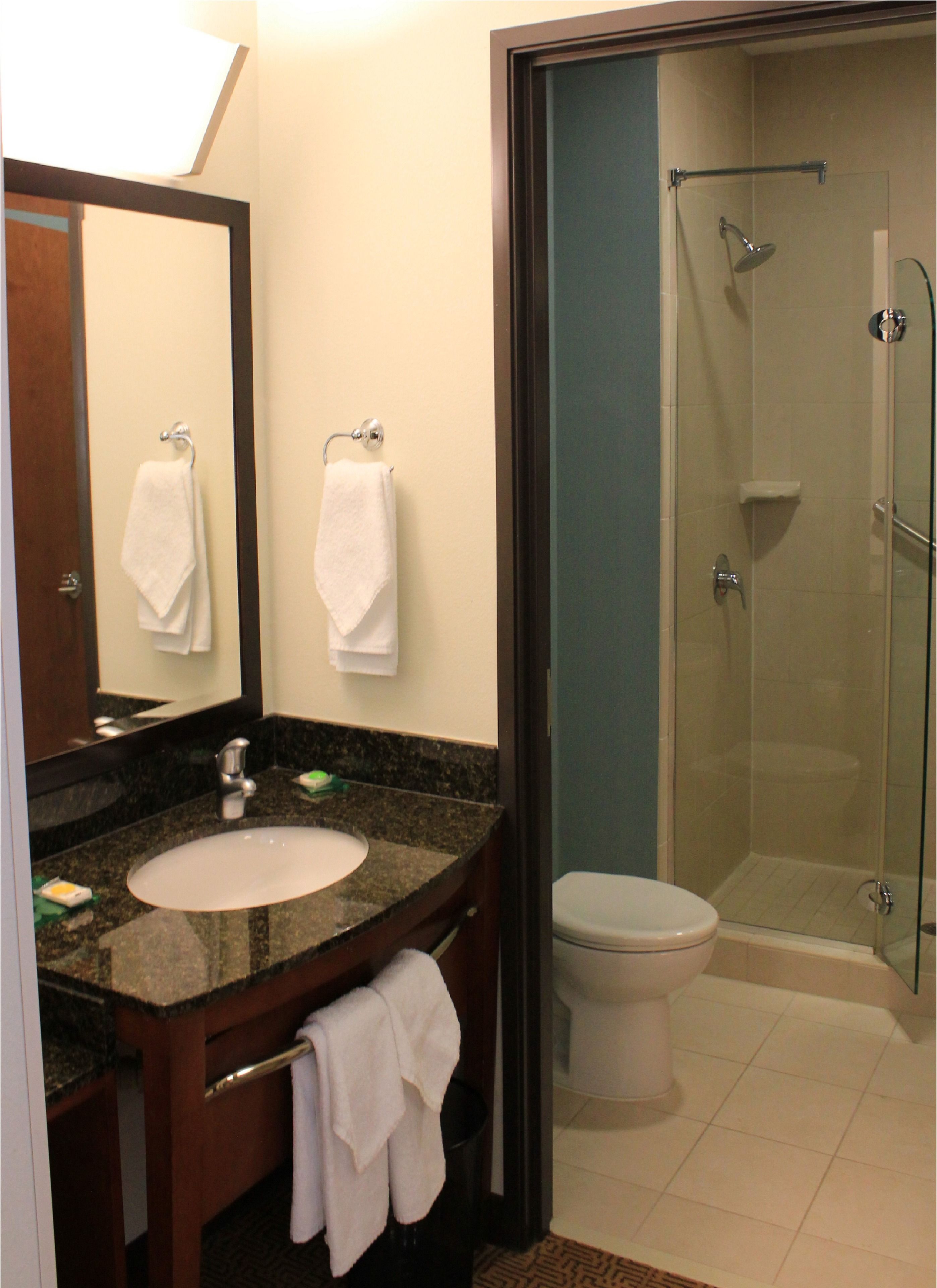 Une salle de bain équipée d’un lavabo, d’un miroir, d’un porte-serviettes et d’une douche à parois de verre.