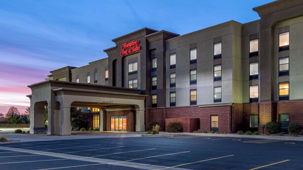 A hotel with a modern facade, a clear entrance, and a parking lot.
