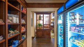A corridor with shelves stocked with snacks and a frozen food display.