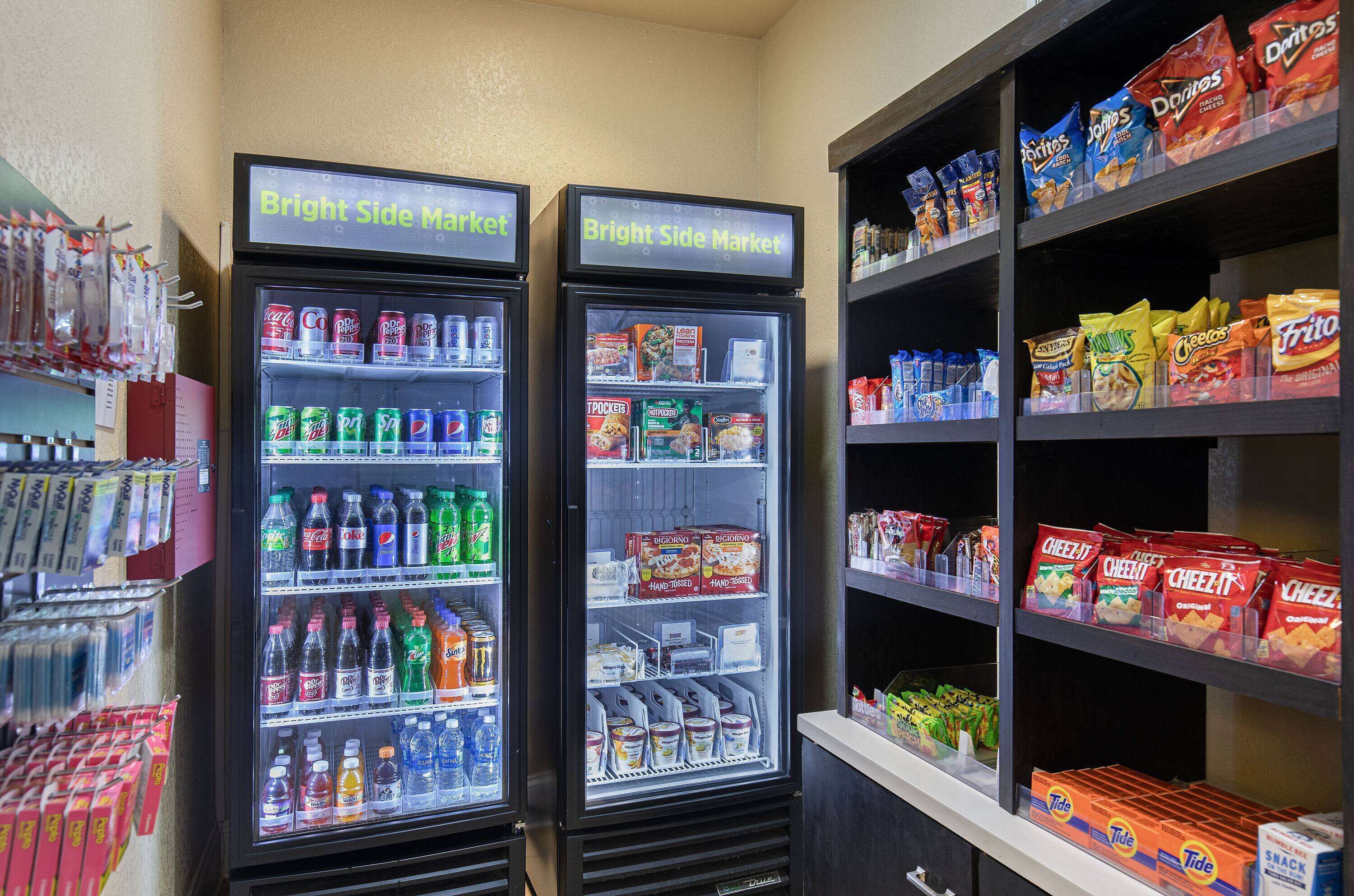 Two beverage vending machines labeled "Bright Side Market" with various drinks and snacks.
