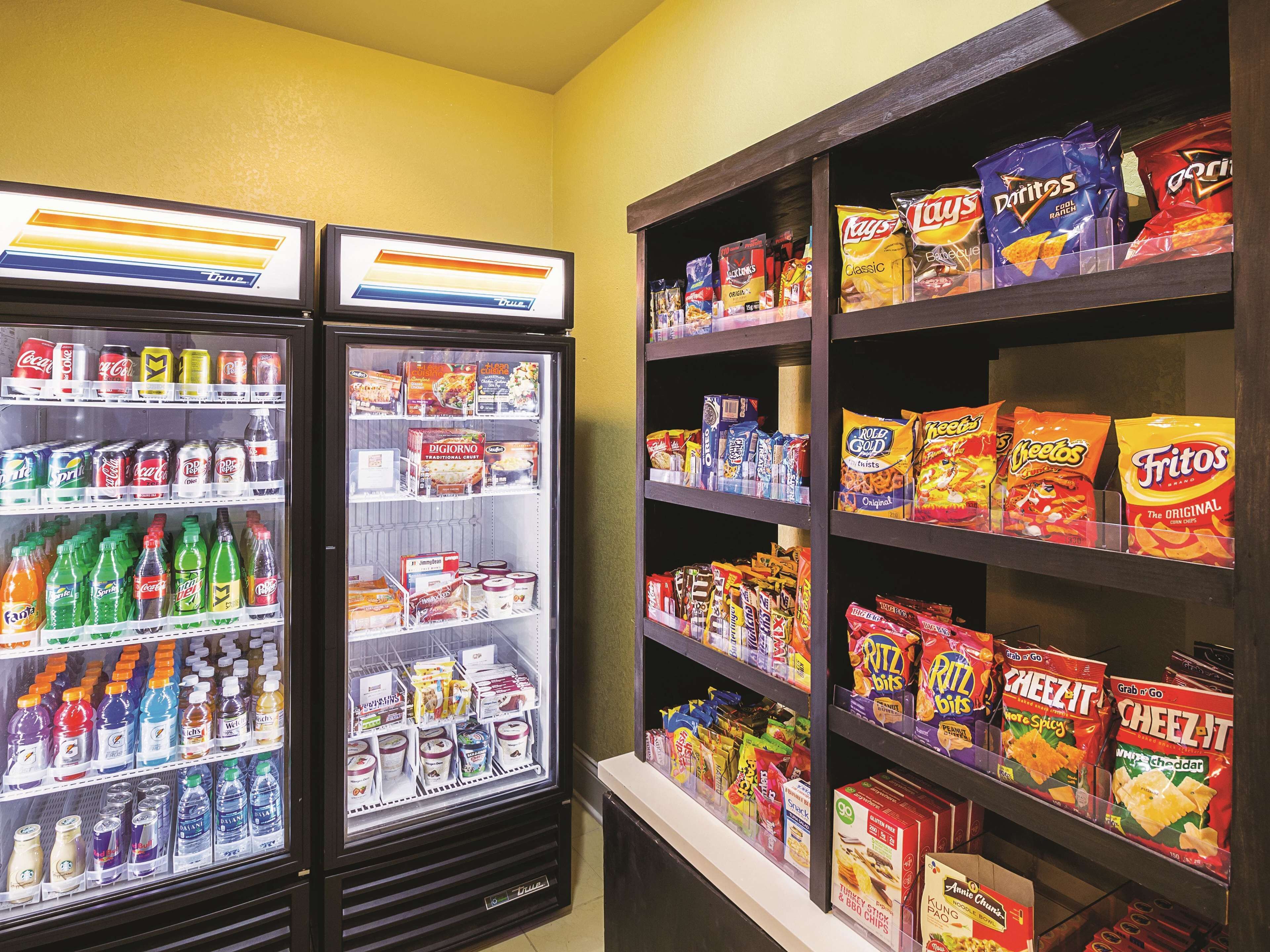 A vending machine stocked with various snacks and beverages, including Doritos, Lay's, and Fritos.