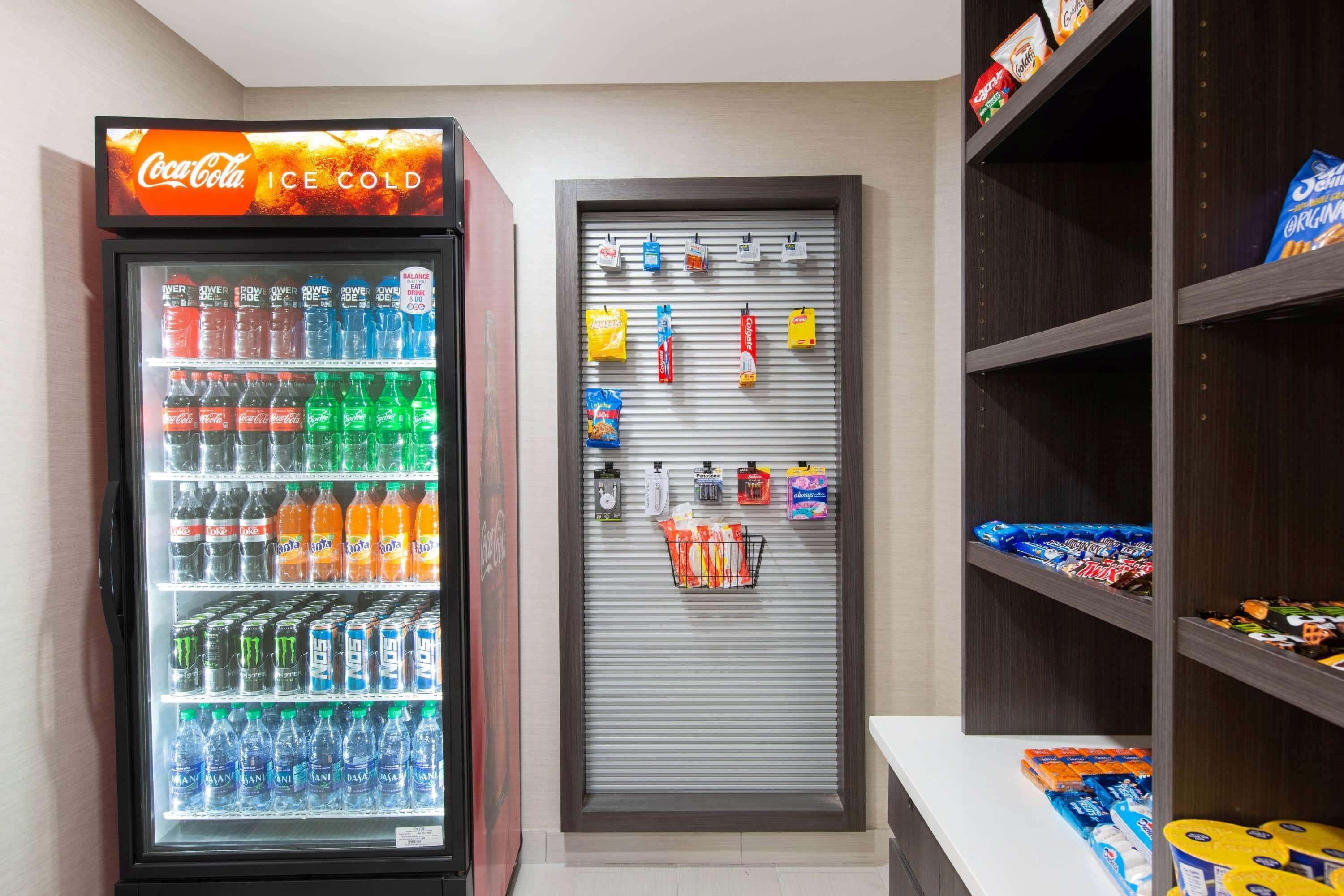 A vending machine with various drinks and snacks, a closed snack bar, and shelves with packaged goods.