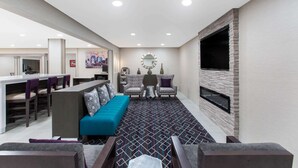 A modern living room with a sofa, chairs, a coffee table, and a fireplace.