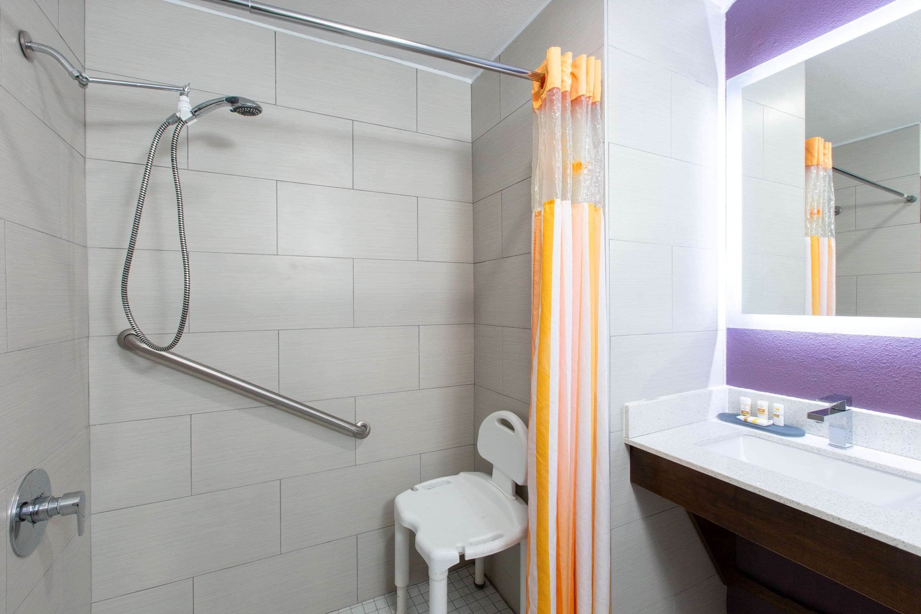 Un baño con ducha, inodoro, lavabo y espejo.