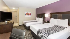 A hotel room with two beds, a TV, a desk, and a chair.