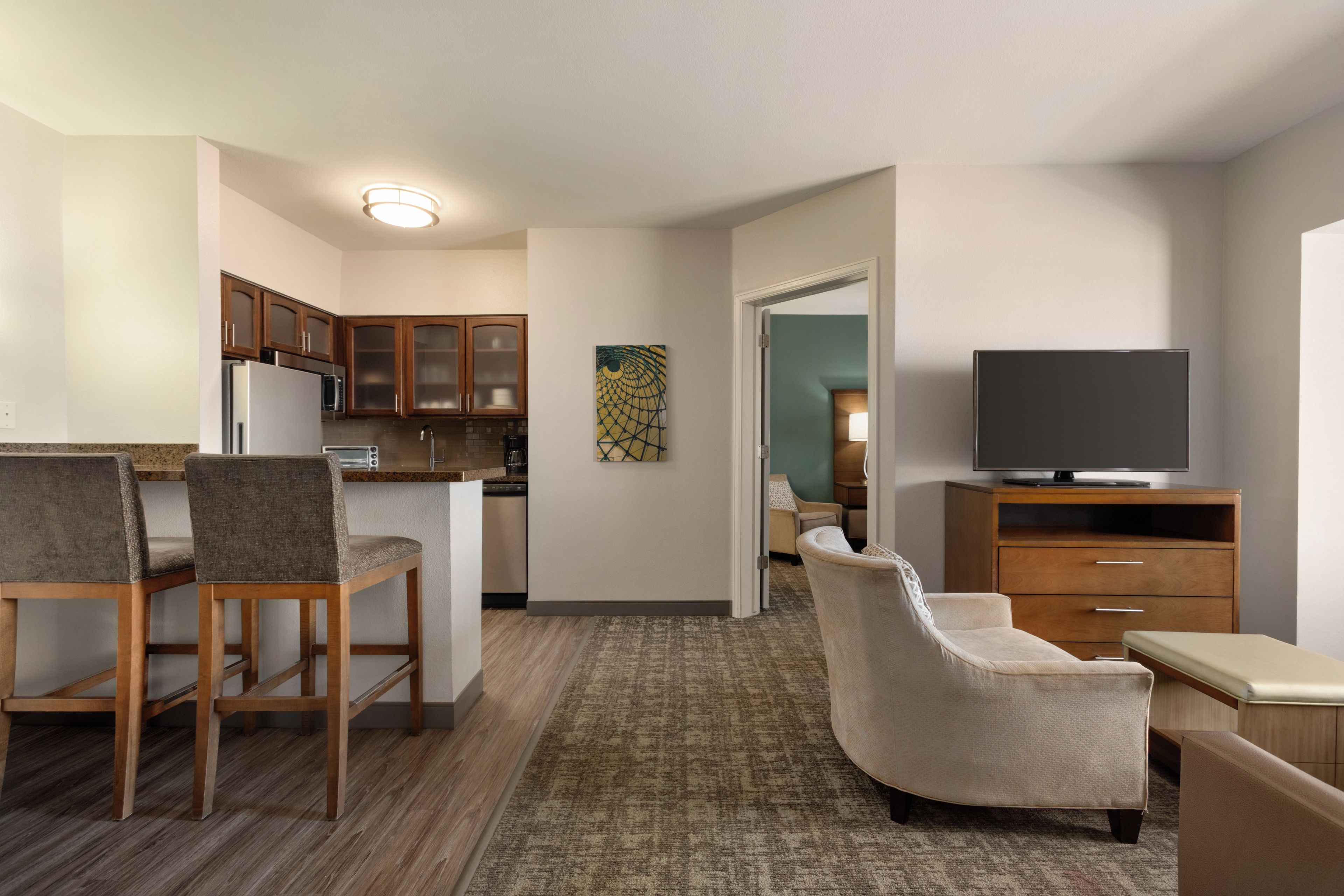 A compact living space with a kitchenette, a dining area, a seating area, and a television.