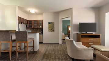 A compact living space with a kitchenette, a dining area, a seating area, and a television.