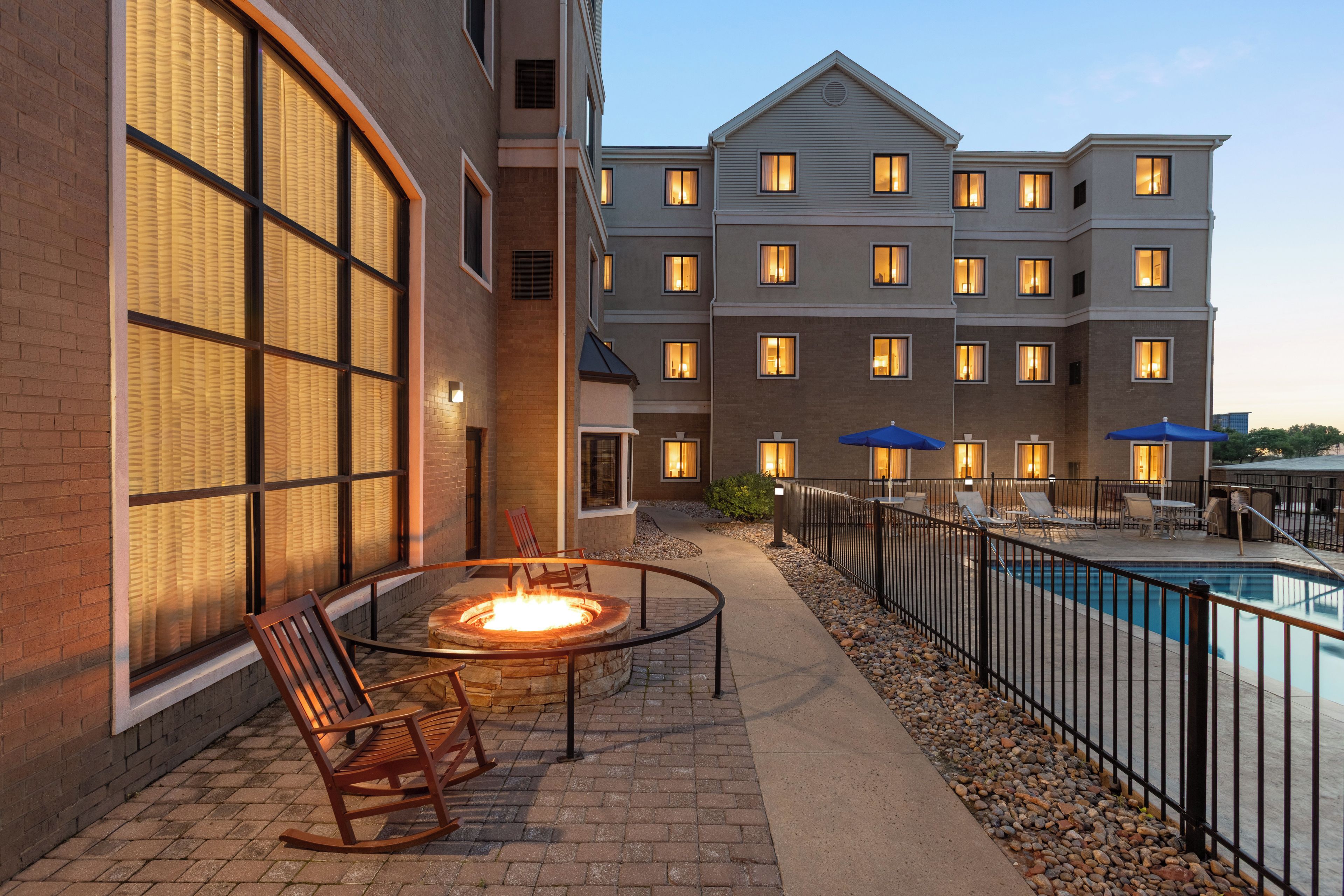 A hotel with a pool area, outdoor seating, and a fire pit.