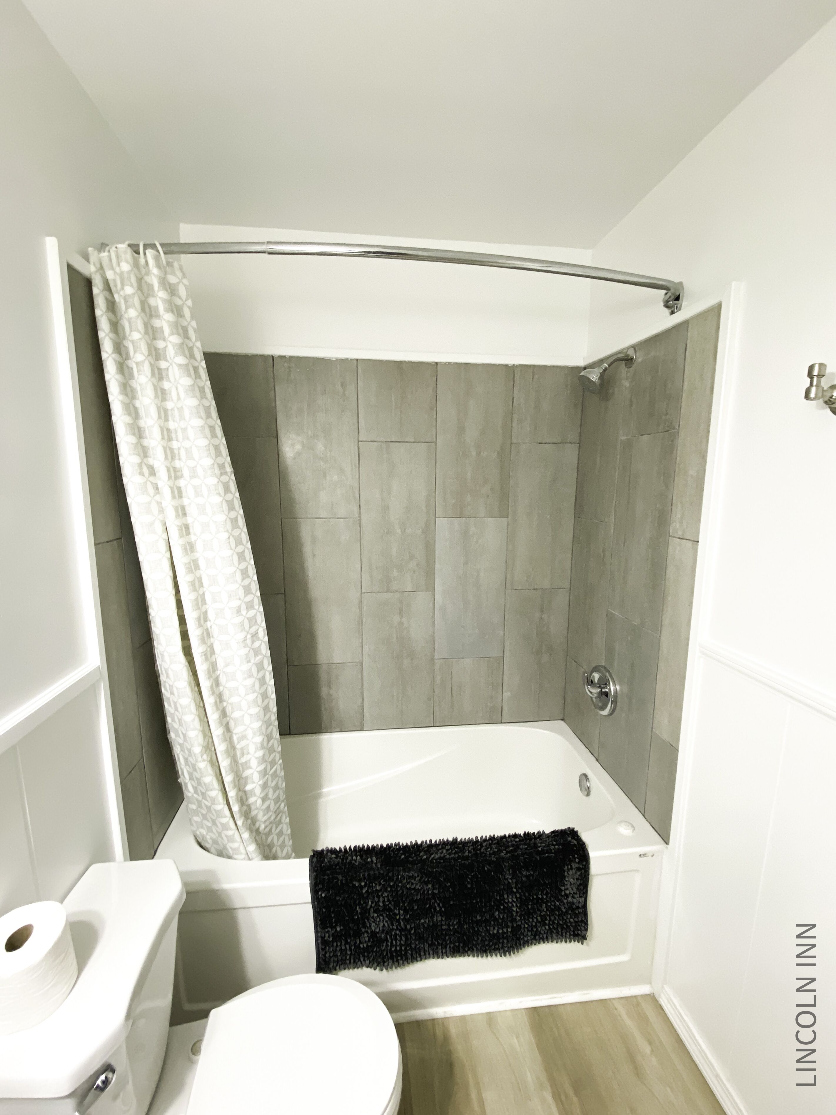 A bathroom with a bathtub, toilet, and shower curtain.