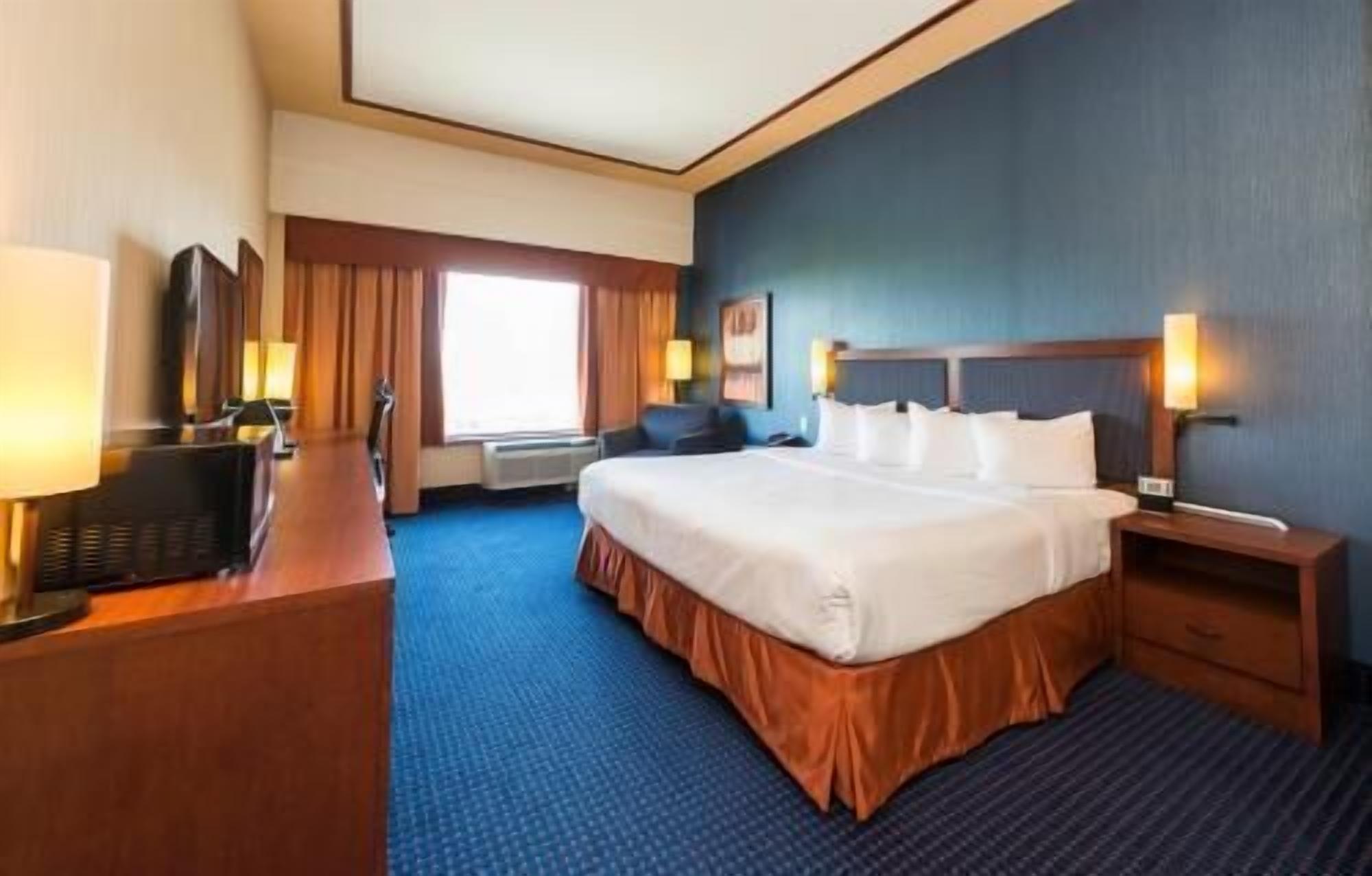 أغطية فراش متميزة وخزنة داخل الغرفة ومكتب وستائر تعتيم