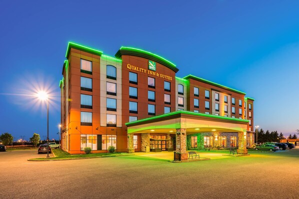 A multi-story hotel with a prominent sign reading "Quality Inn & Suites." - Quality Inn & Suites Levis (Levis)
