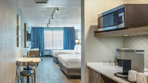 A hotel room with a kitchenette, a dining area, a bed, and a TV. - Quality Inn & Suites Levis (Levis)