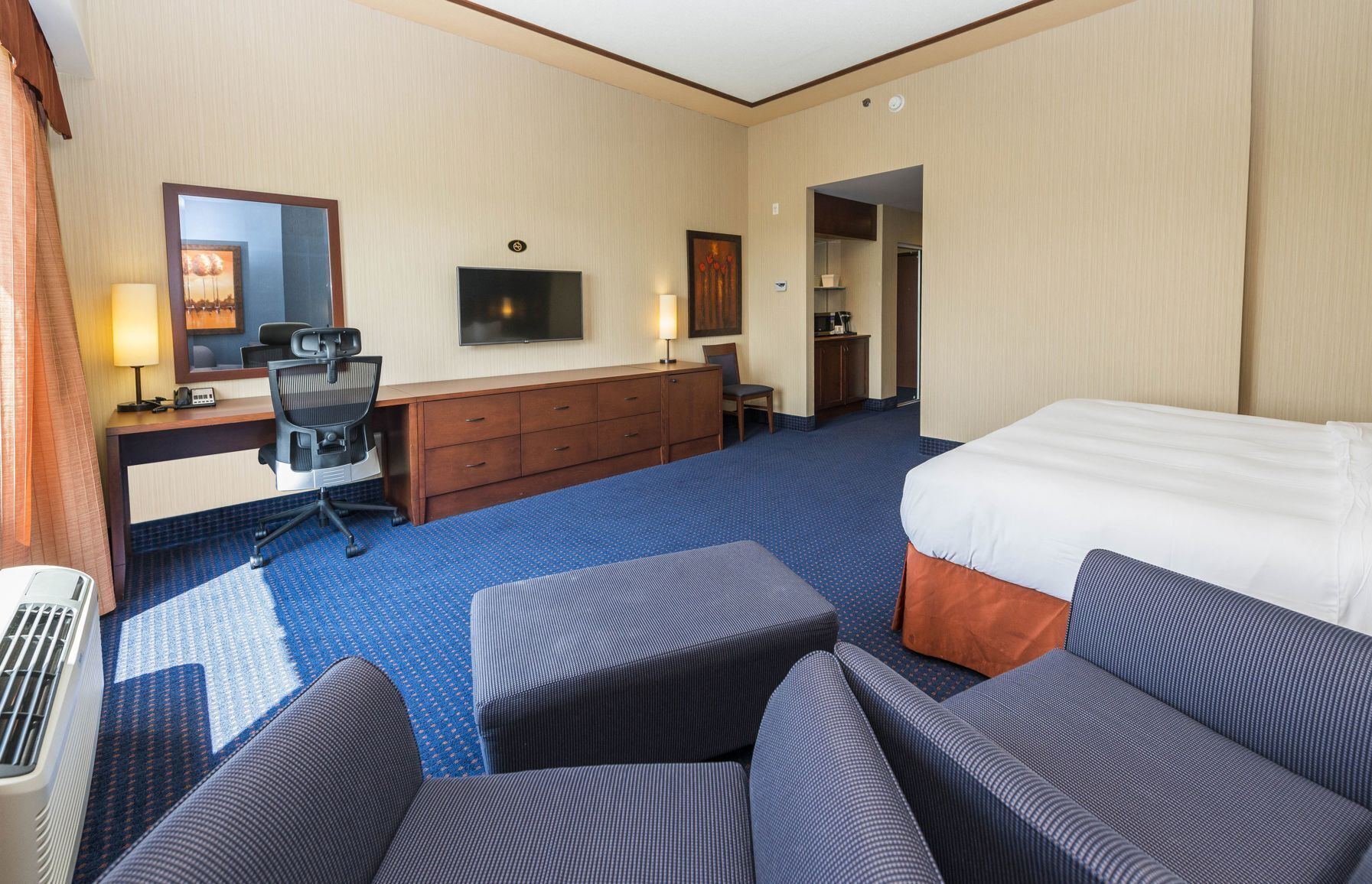 أغطية فراش متميزة وخزنة داخل الغرفة ومكتب وستائر تعتيم