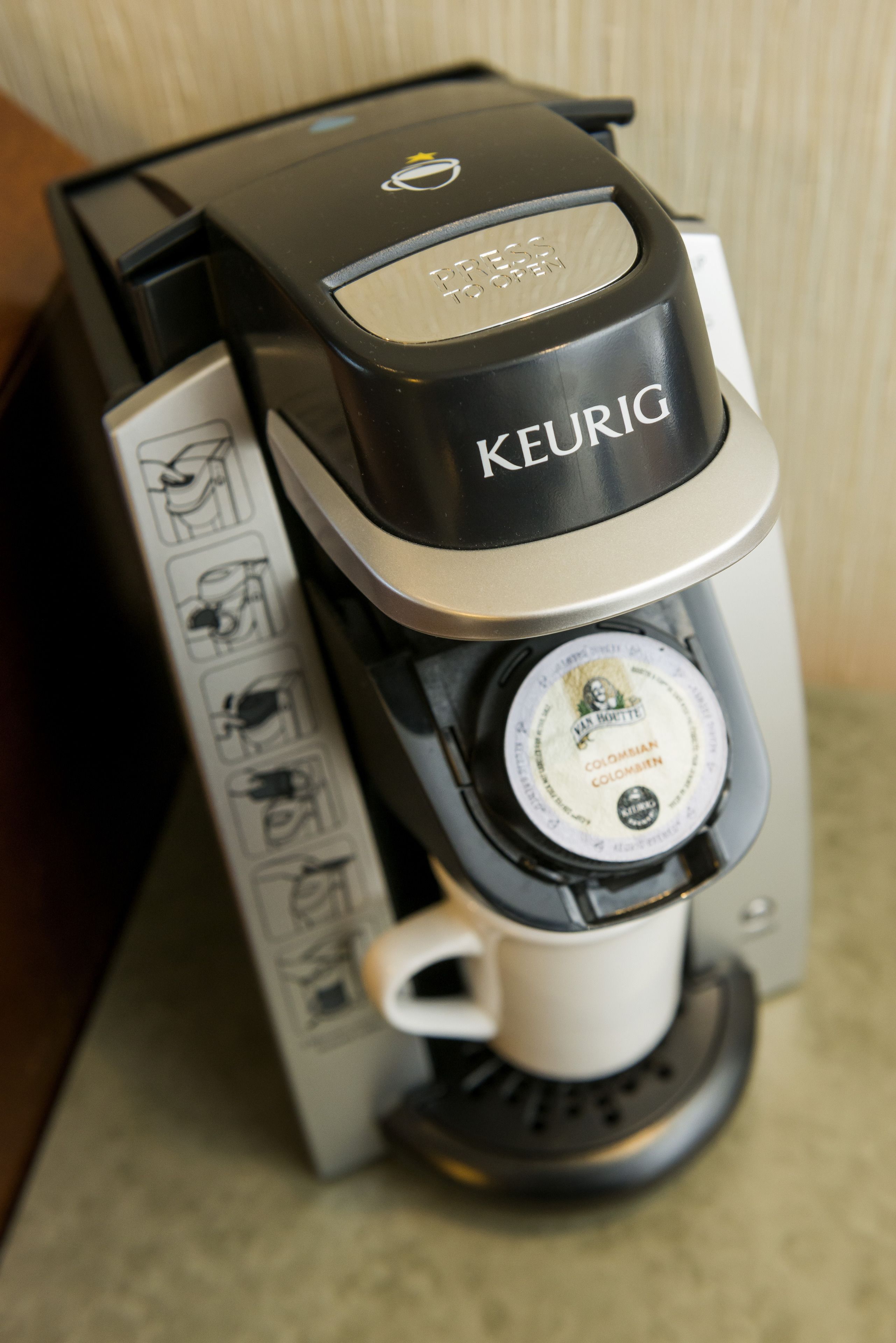 Una cafetera Keurig con un portacapsulas de café e instrucciones.