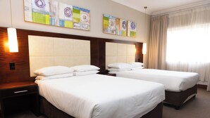 A hotel room with two beds, a wooden headboard, a nightstand, and artwork on the wall. - Premier Splendid Inn Pinetown (Pinetown)
