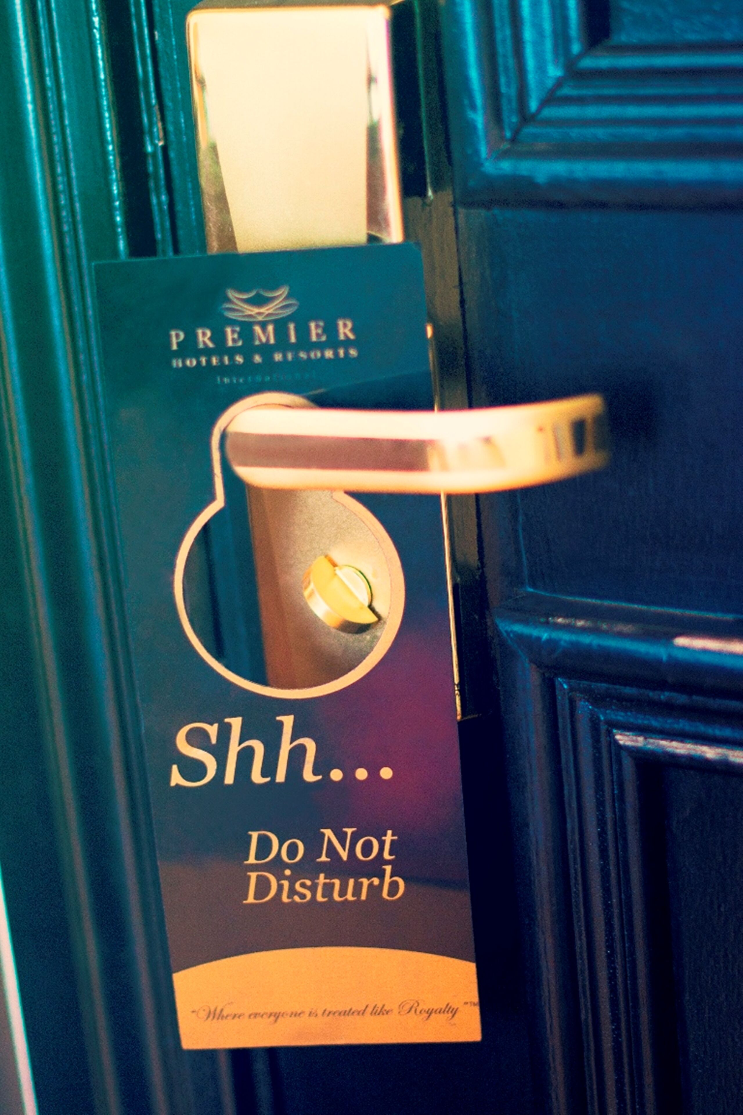 Una puerta con un letrero que dice "Shh... No molestar" y "Premier Hotels & Resorts".