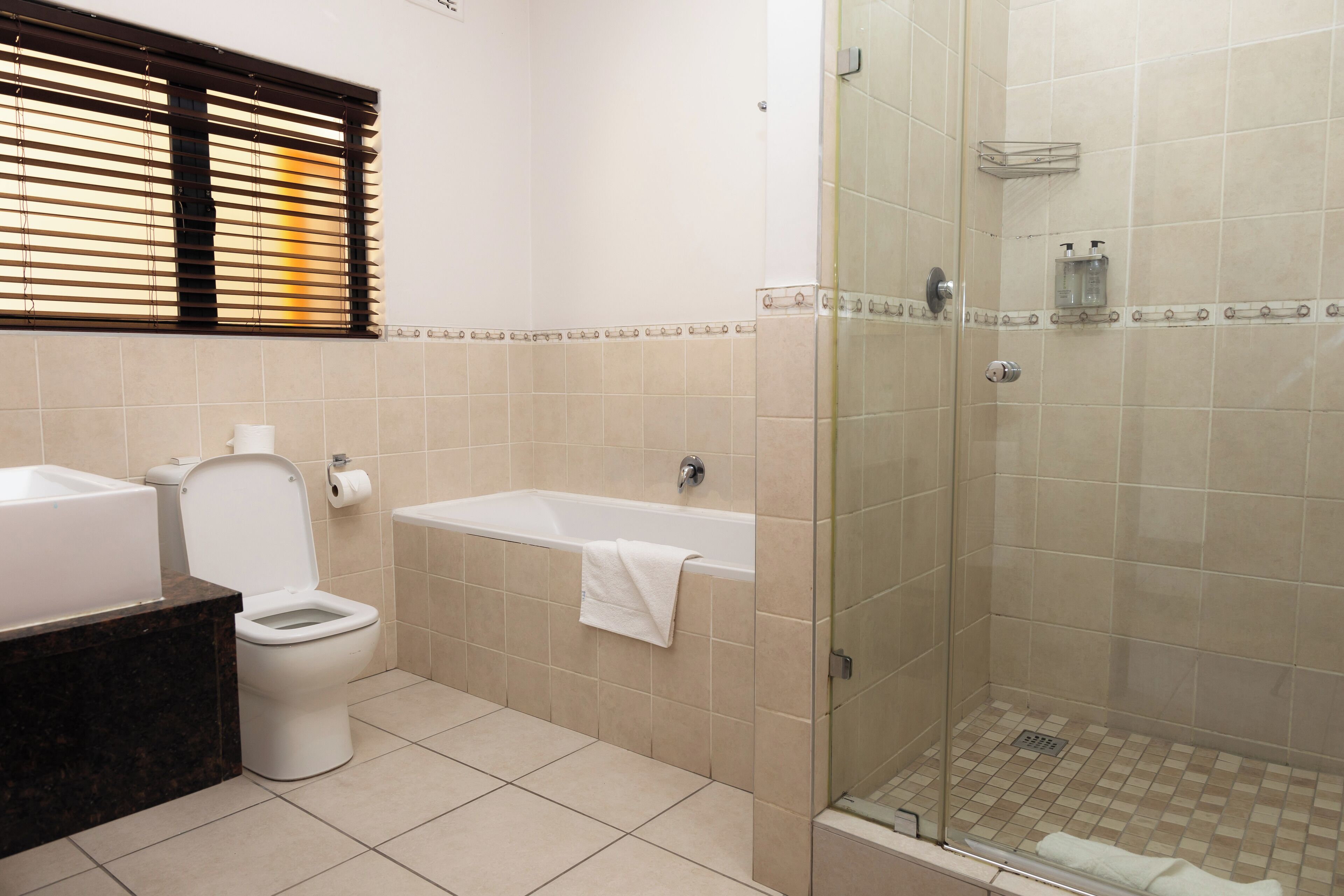 A bathroom with a toilet, bathtub, and glass-enclosed shower.