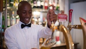 A person pouring a drink from a tap. - The Edwardian (Port Edward)