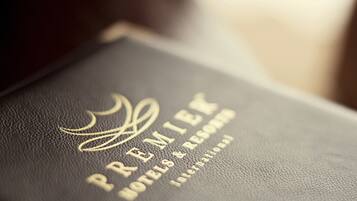 A black leather-bound book with embossed gold text reading "PREMIER HOTELS & RESORTS INTERNATIONAL."