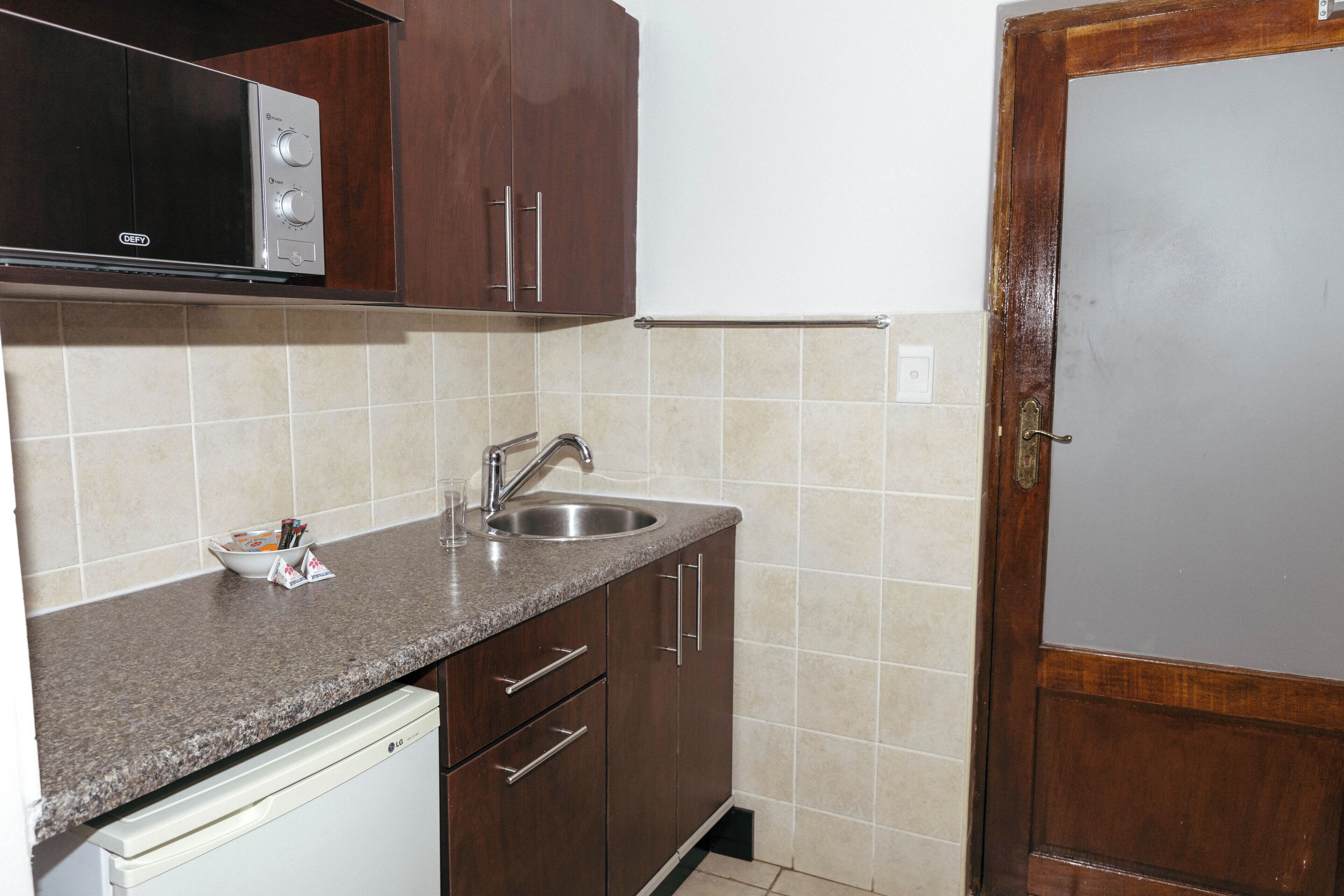 A kitchen with a microwave, sink, and cabinets.