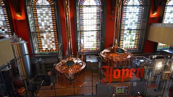 A distillery with large copper stills, stained glass windows, and a sign indicating the distillery is open.