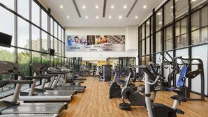 Ein Fitnessstudio mit Laufbändern, Crosstrainern und Kraftgeräten.
