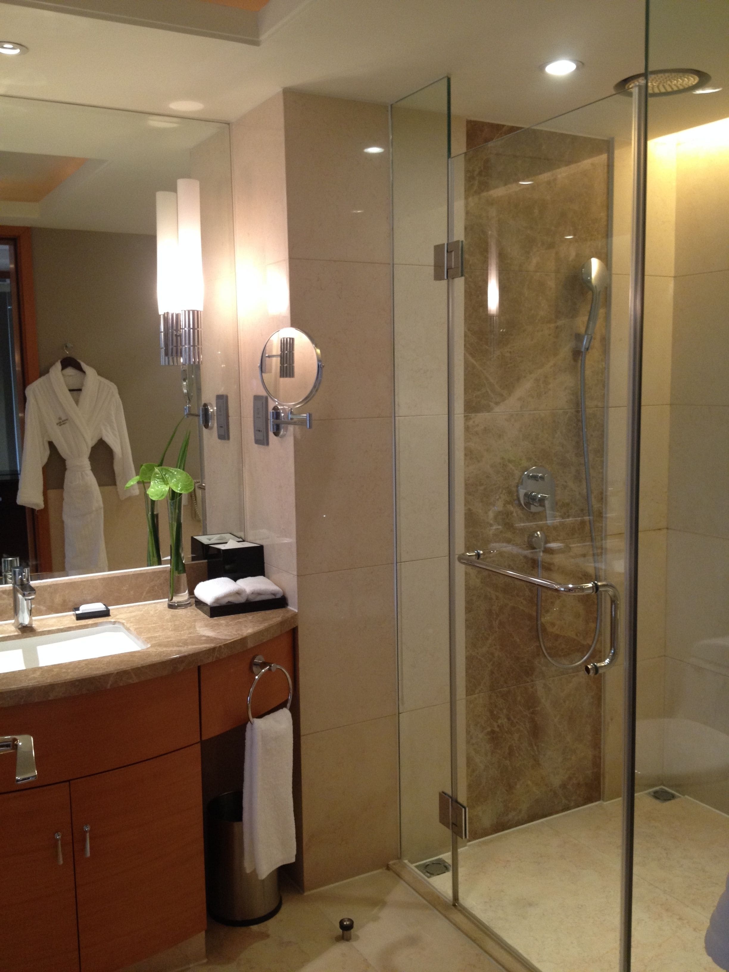 Une salle de bain moderne avec une douche à parois de verre, un meuble-lavabo et un miroir.