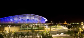 A large, illuminated stadium with a curved roof, surrounded by palm trees and a waterfront. - Adina Apartment Hotel Darwin Waterfront (Darwin)