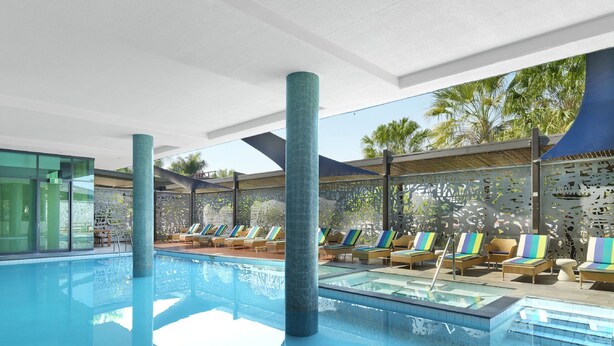 Un área de piscina con sillas de descanso y vista despejada a la piscina.
