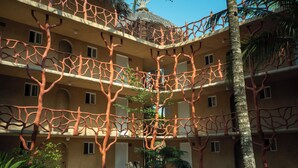 Un edificio de varios pisos con un diseño arquitectónico único que recuerda a un árbol, con balcones y ventanas.