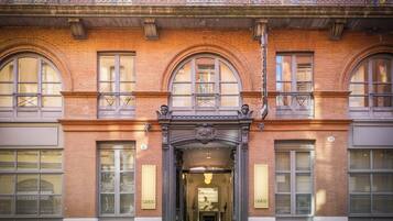 A grand building with a classic architectural style, featuring arched windows and a detailed entrance.