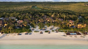 A resort with multiple buildings, a beach, and a golf course.