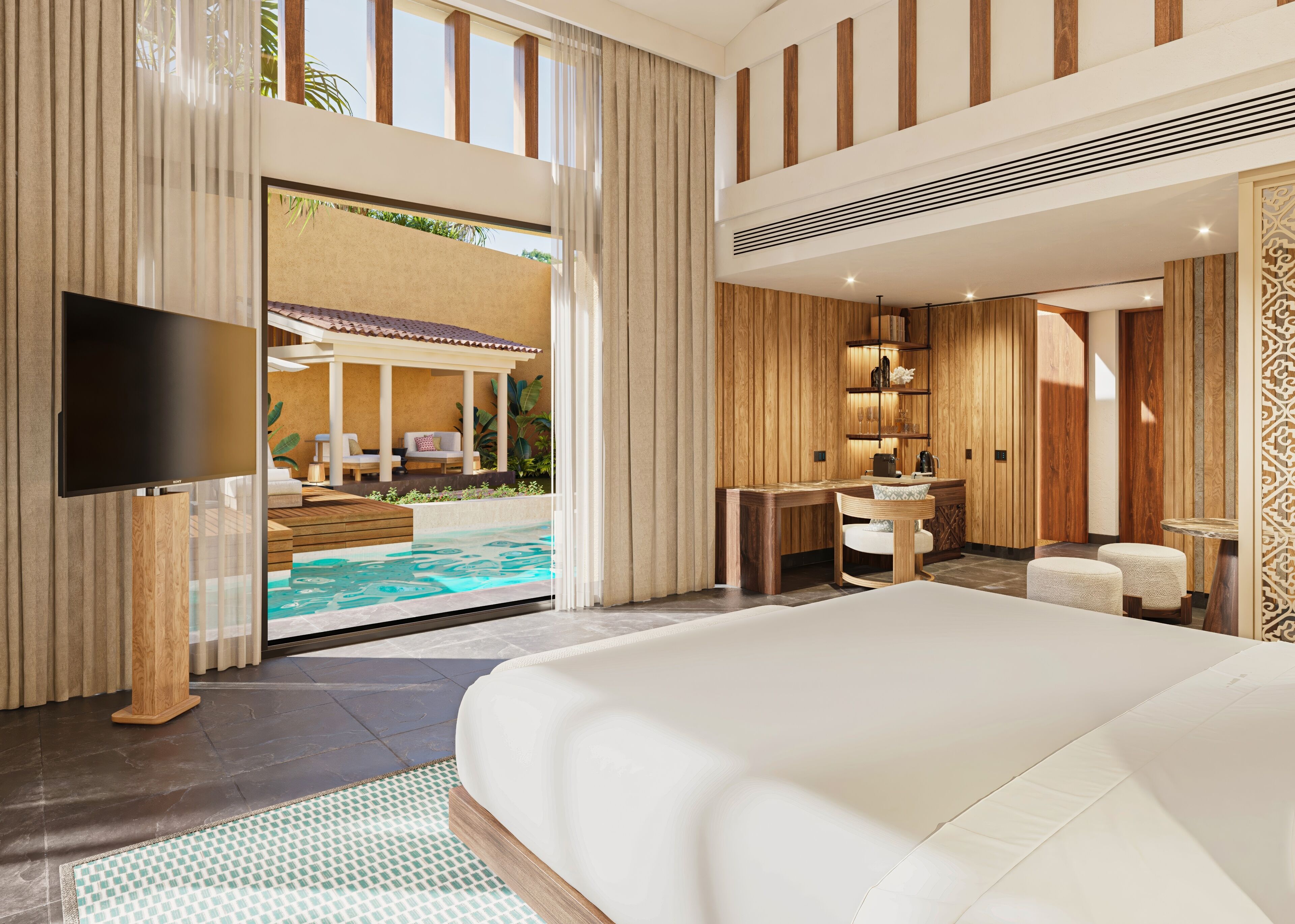 A modern hotel room with a large bed, a desk, and a view of an outdoor pool area.