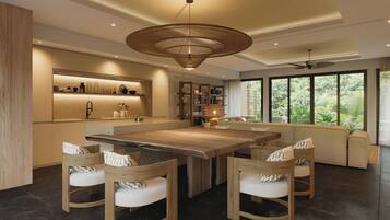 A modern kitchen with a central island, built-in shelves, and a large window offering a view of greenery.