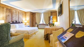 A hotel room with two beds, a round table with chairs, and a large mirror.