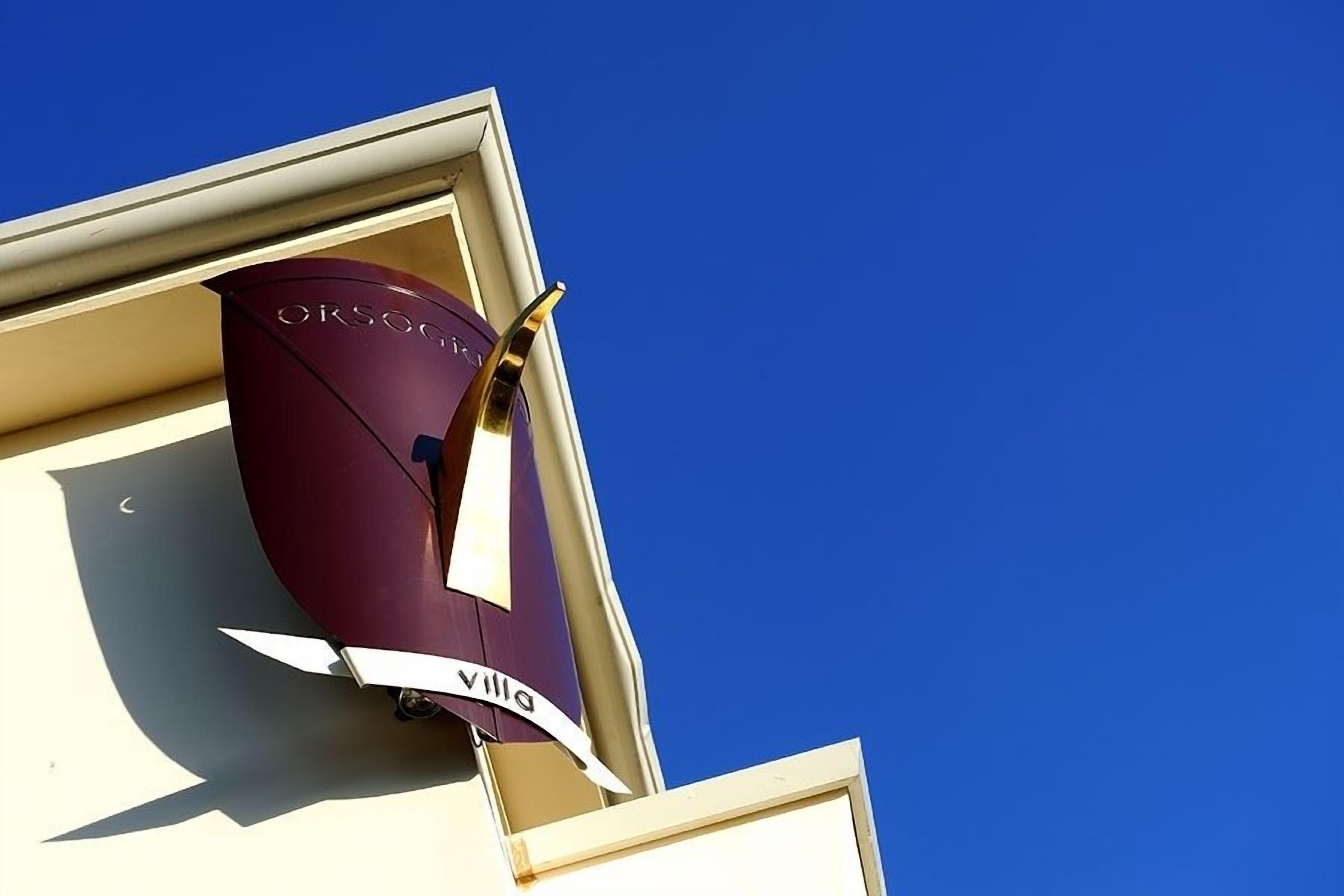 A building corner with a purple awning and a sign that reads "ORSOGNIA."