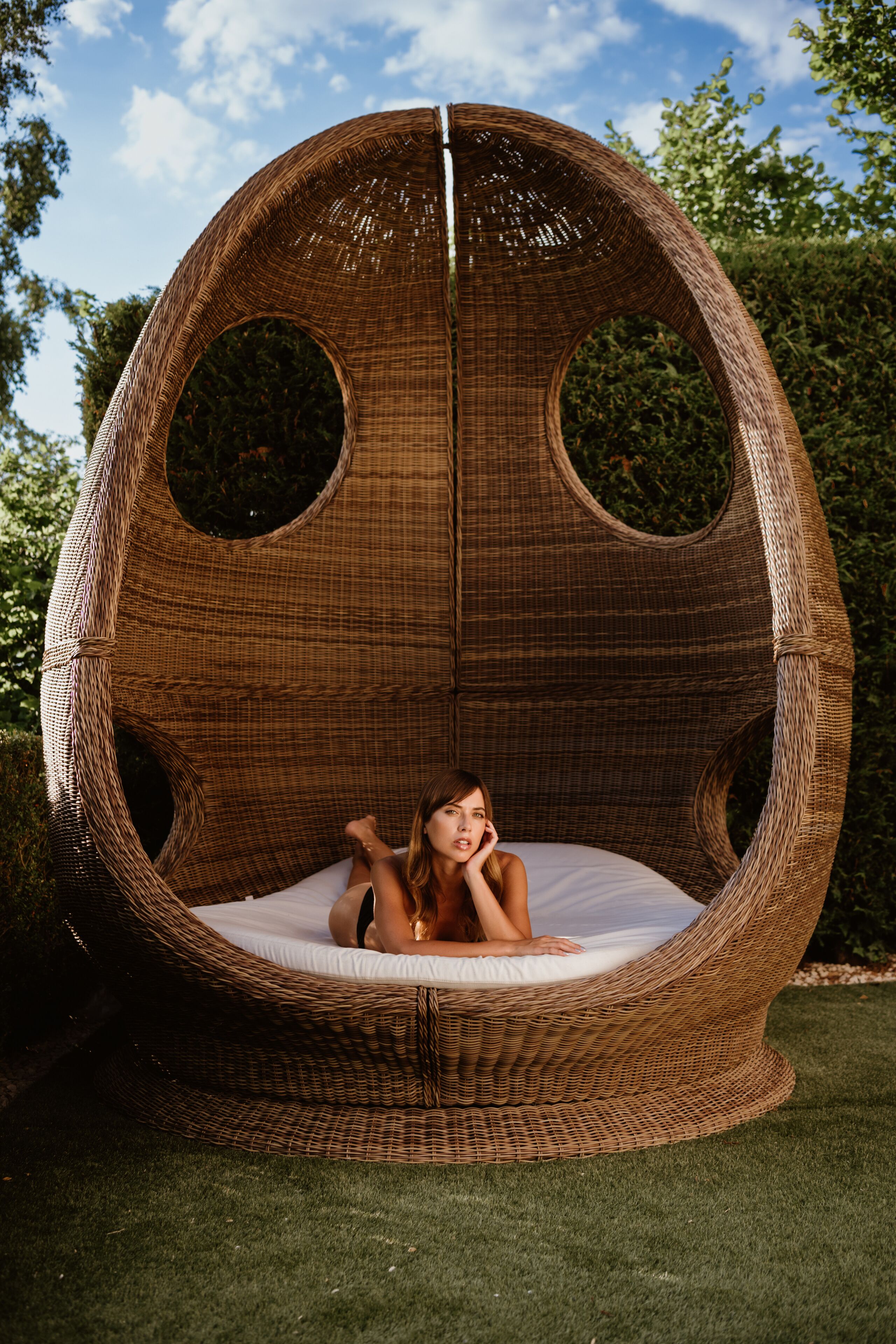 A wicker chair with a circular design and a white cushion.