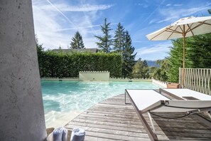 Piscina a l'aire lliure de temporada, para-sols i gandules 