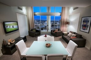 Una sala de estar moderna con una mesa de comedor, sofás y una televisión.