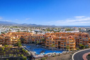A resort with multiple buildings, a swimming pool, and a view of the surrounding landscape. - Grand Muthu Golf Plaza Hotel (San Miguel de Abona)