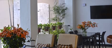 Eine Sitzecke mit zwei Stühlen, einem Tisch und einer Blumenvase.